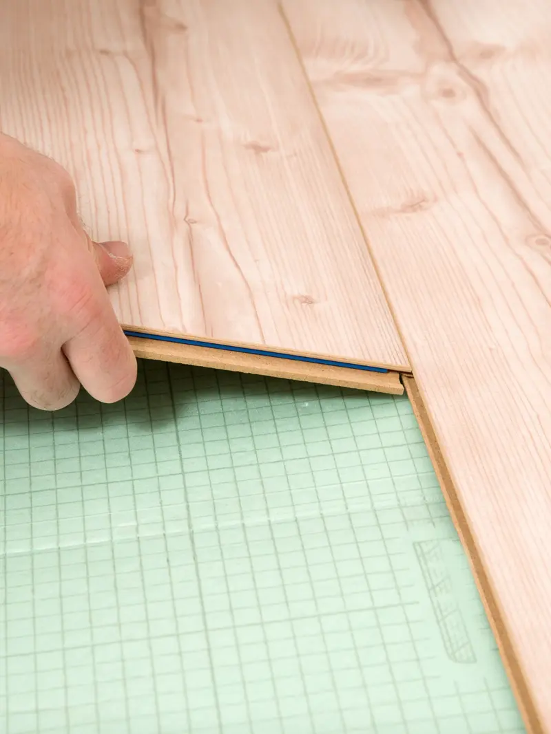 Photo pose d'un sol avec du parquet straifié et son réagréage